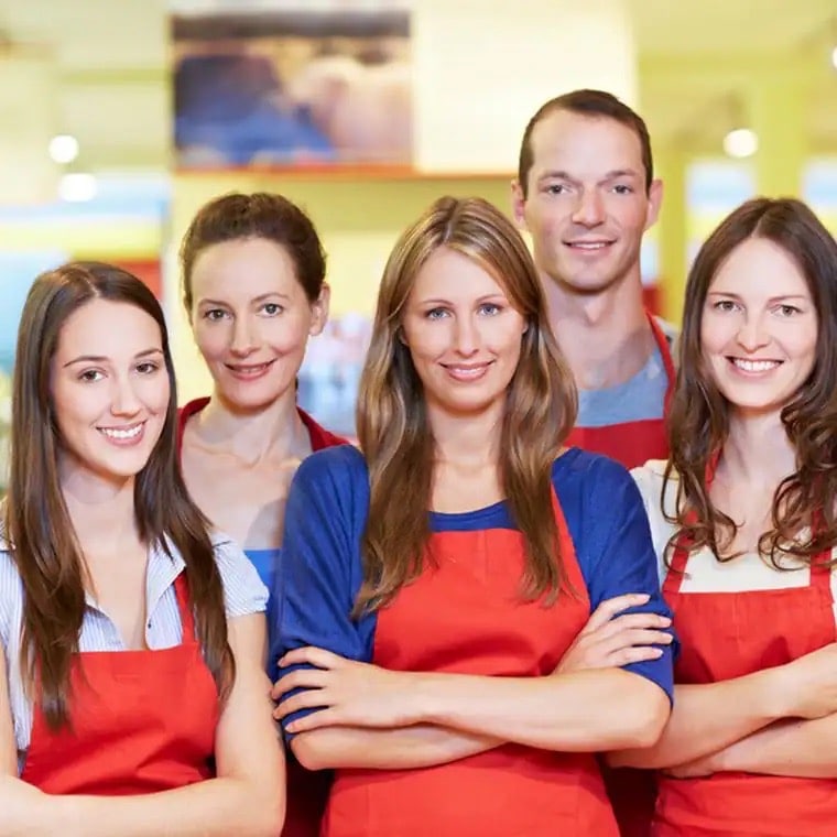 Fünf junge Menschen in roten Schürzen.