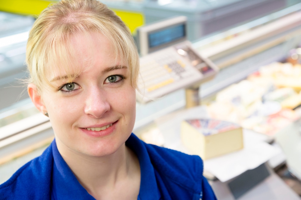 Lächelnde Frau mit blonden zurückgebundenen Haaren.