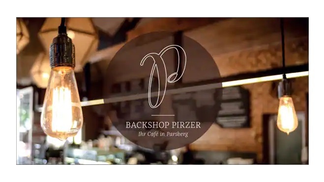 Logo des Backshop Pirzer – Ihr Café in Parsberg zwischen zwei dekorativen Glühbirnen.
