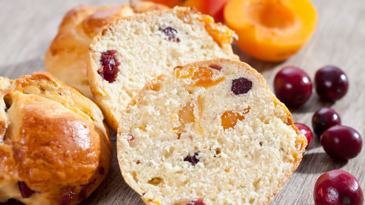 Nahaufnahme eines aufgeschnittenen Brötchens mit Aprikosen und Cranberries.