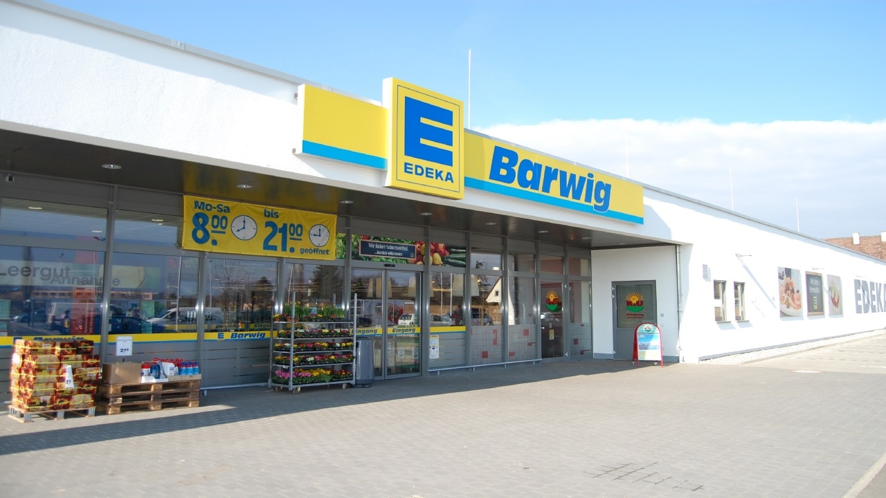 EDEKA Barwig von außen mit Öffnungszeiten (Mo–Sa 8–21 Uhr) und Auslage von Waren vor dem Eingang.