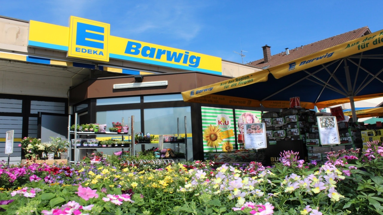 EDEKA Barwig Filiale mit bunter Blumen-Auslage und Werbeschirmen im Außenbereich.
