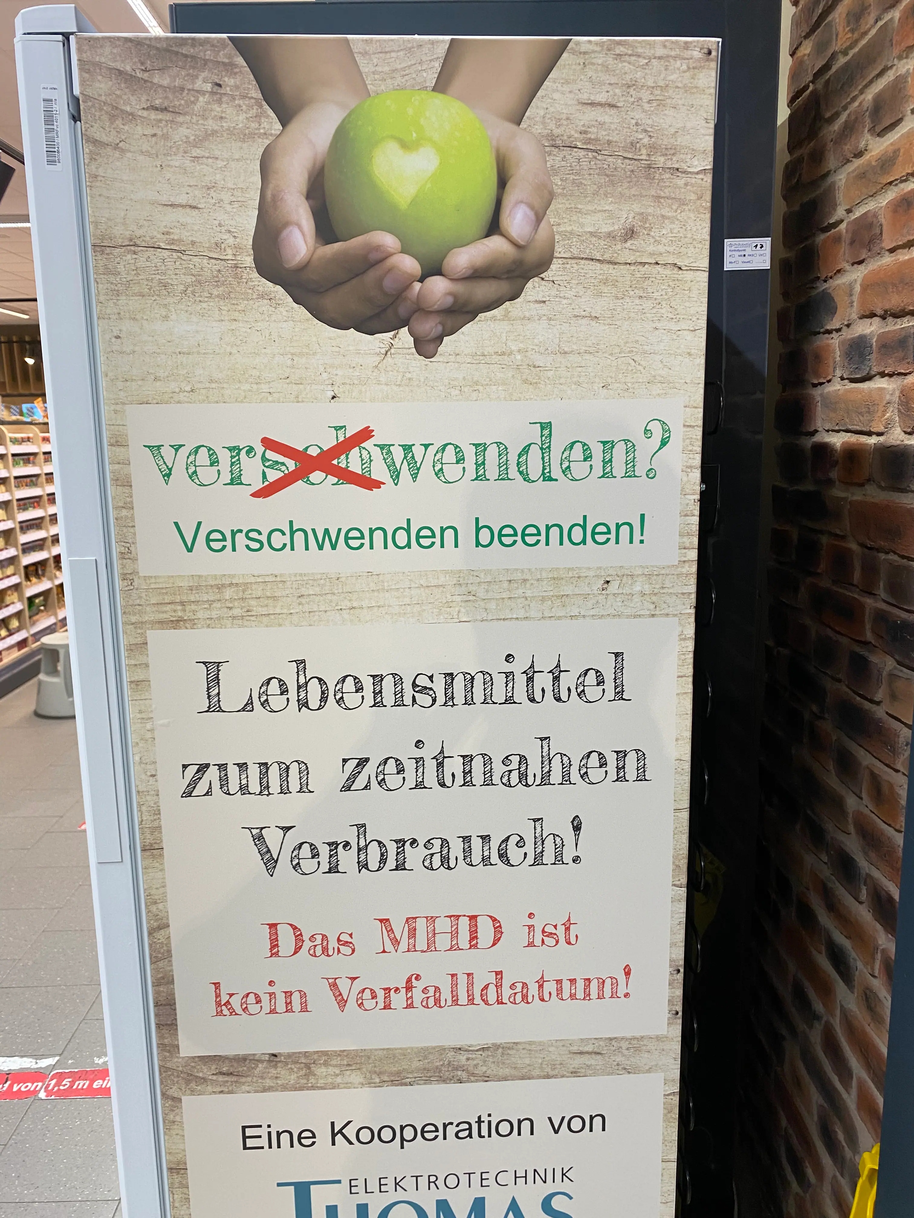 Ein Kühlschrank auf dessen Seite steht: "Verschwenden beenden!" Lebensmittel zum zeitnahen Verbrauch! Das MHD ist kein Verfallsdatum!