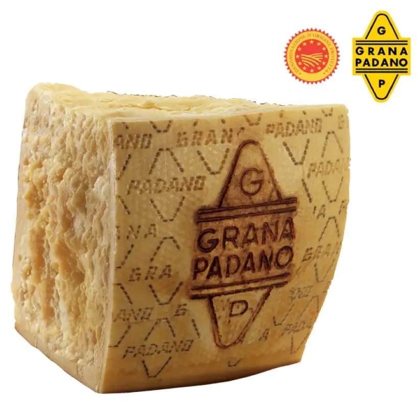 Großes quadratisches Stück Parmesan Hartkäse. Auf der Rinde steht Grana Padano.