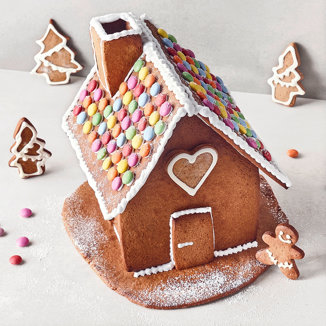Ein Lebkuchenhaus mit Zuckerguss und bunten Smarties