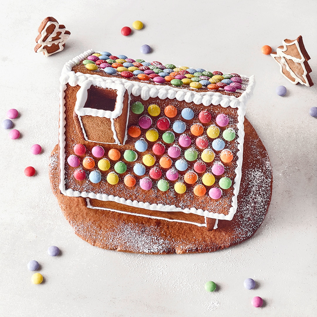 Ein Lebkuchenhaus mit Zuckerguss und bunten Smarties