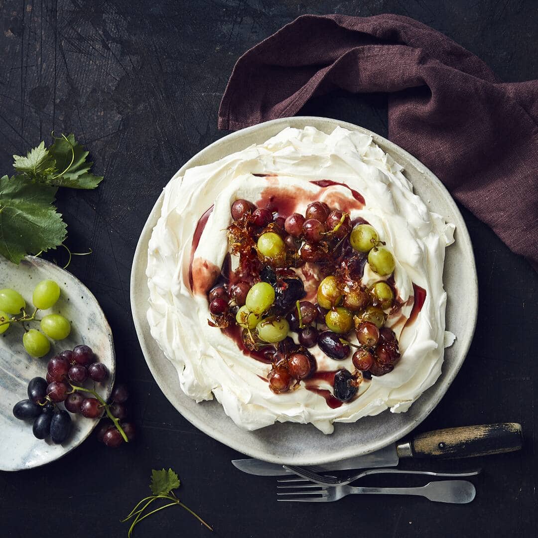 Die Pavlova kommt ursprünglich aus Australien oder Neuseeland - wir servieren die luftige Baisertorte mit einem Meer an süßen karamellisierten Trauben.