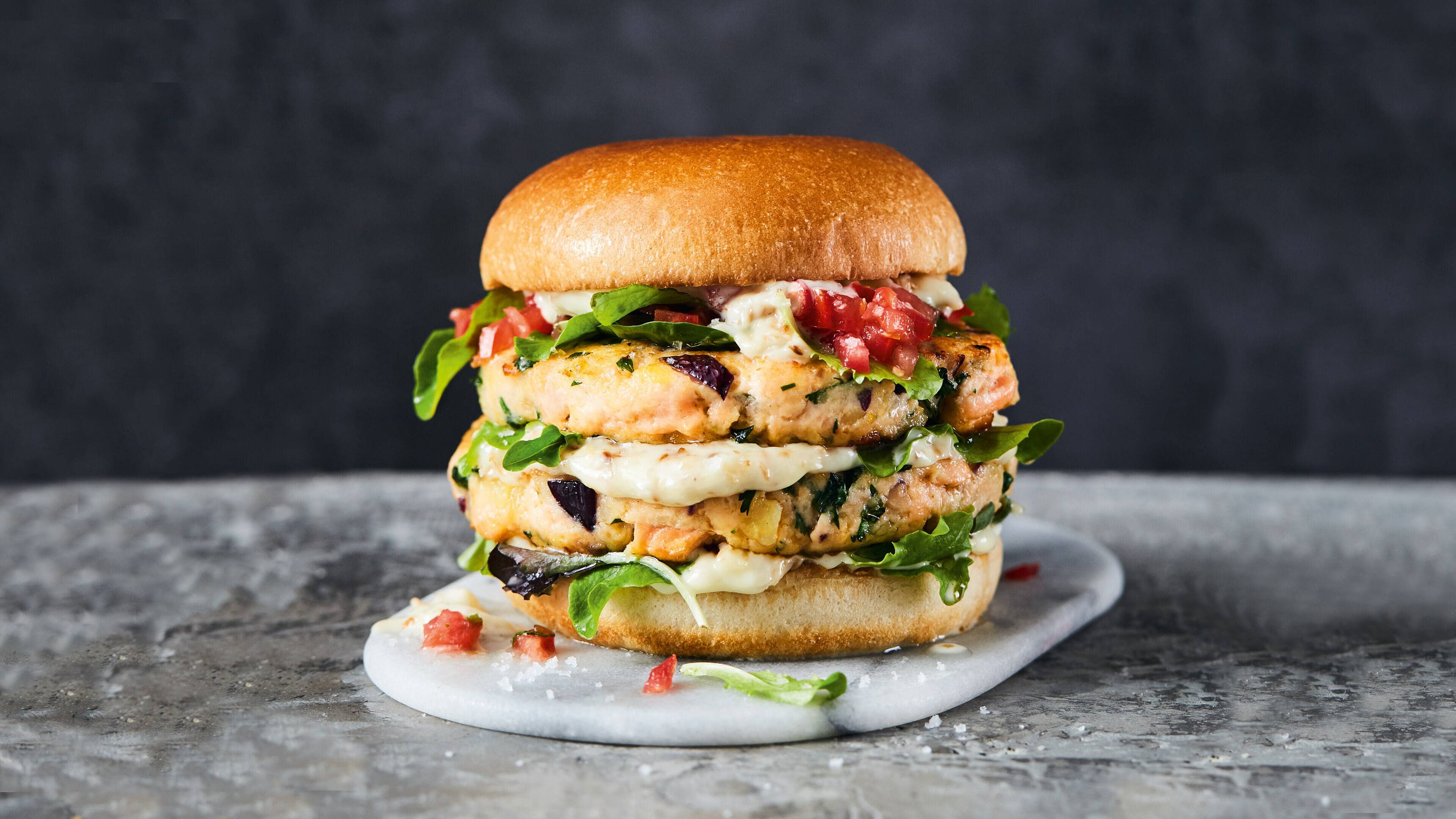 Thai-Fish-Burger Burger mal anders: Probieren Sie unseren Spice Thai-Fisch-Burger mit Lachs, Kartoffeln, Tomaten, Minze und Koriander.