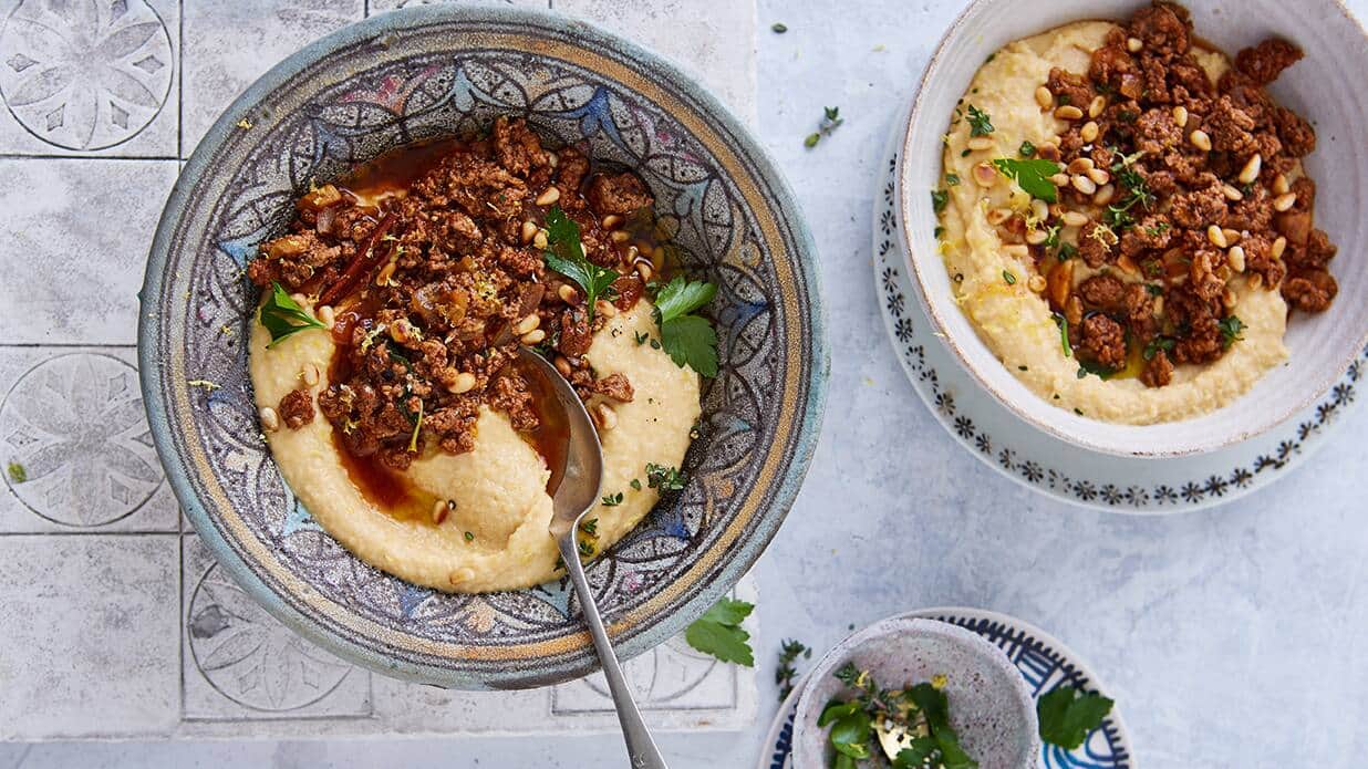 Hummus mit Lammsugo Die orientalische Spezialität Hummus lässt sich einfach Selbermachen: Probieren Sie den cremigen Kichererbsenbrei mit einem Lammsugo und garnieren das Ganze mit Petersilie und Pinienkernen.