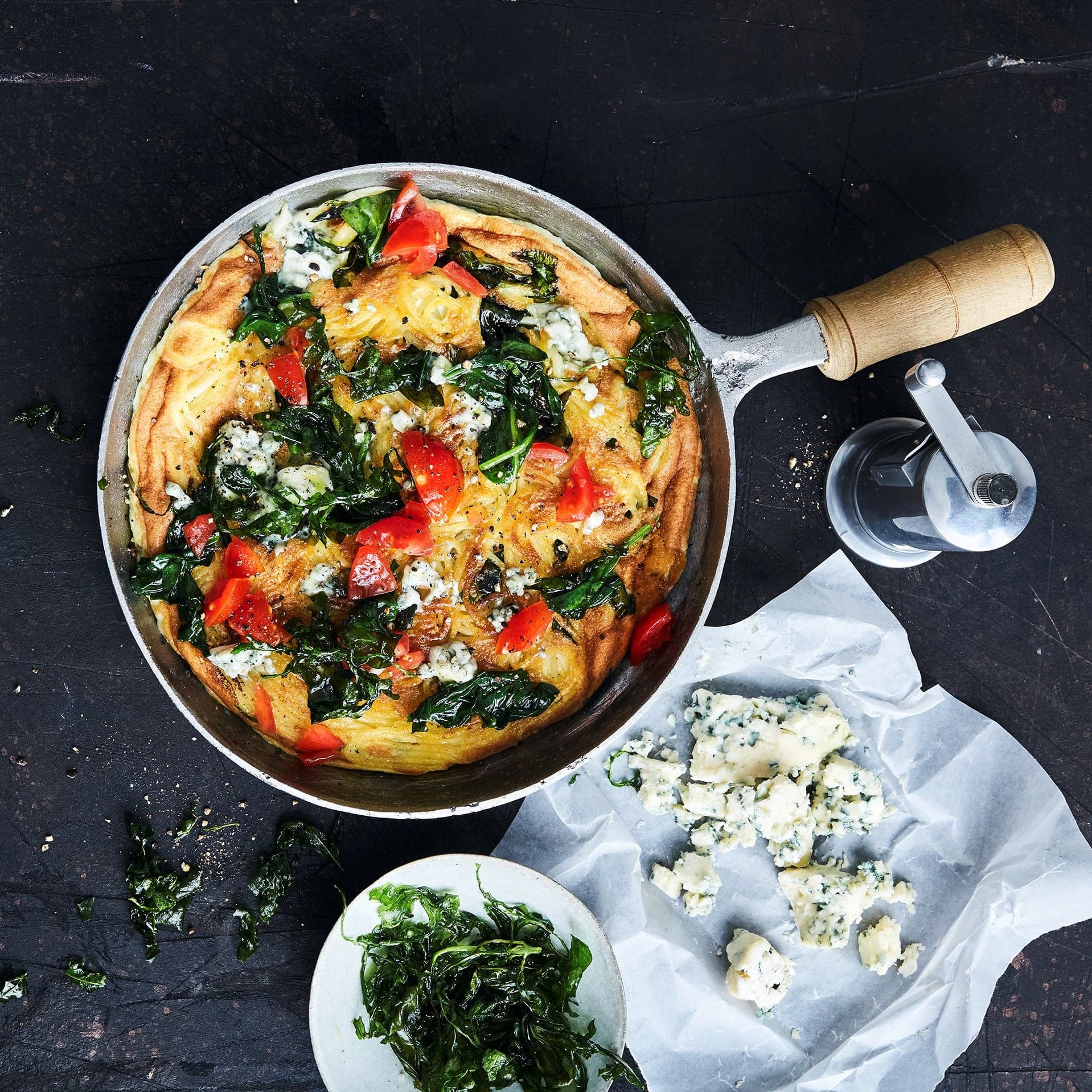 Spaghetti-Omelette mit Spinat und Blauschimmelkäse, belegt mit Tomaten und frittiertem Rucola. So wird aus einem einfachen Omelette ein kulinarischer Gaumenschmaus!