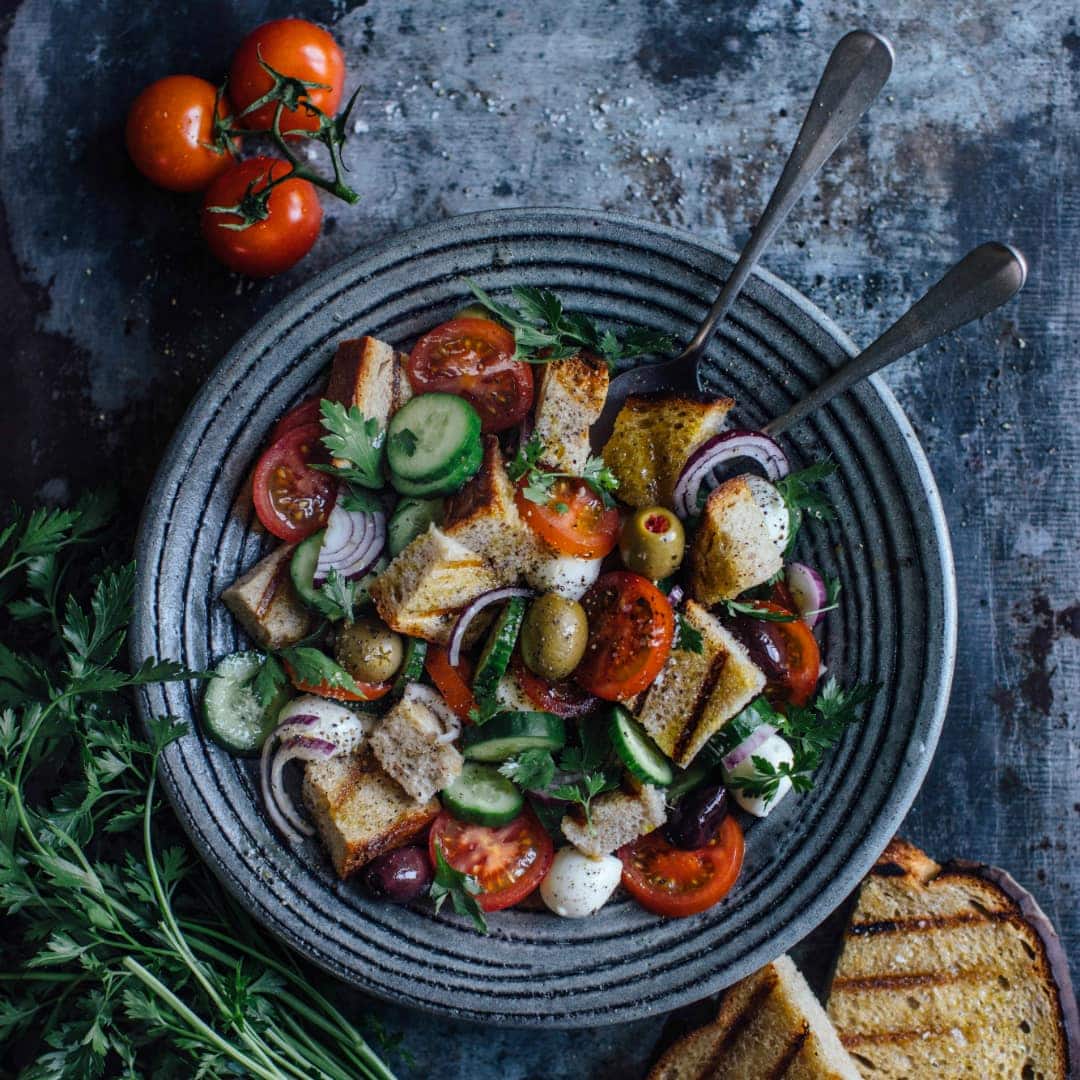 Wie wäre es an einem warmen Sommerabend mit einem Brotsalat? Gegrilltes Brot, Tomaten und Mozzarella machen diesen Salat zu einem echten Leckerbissen.