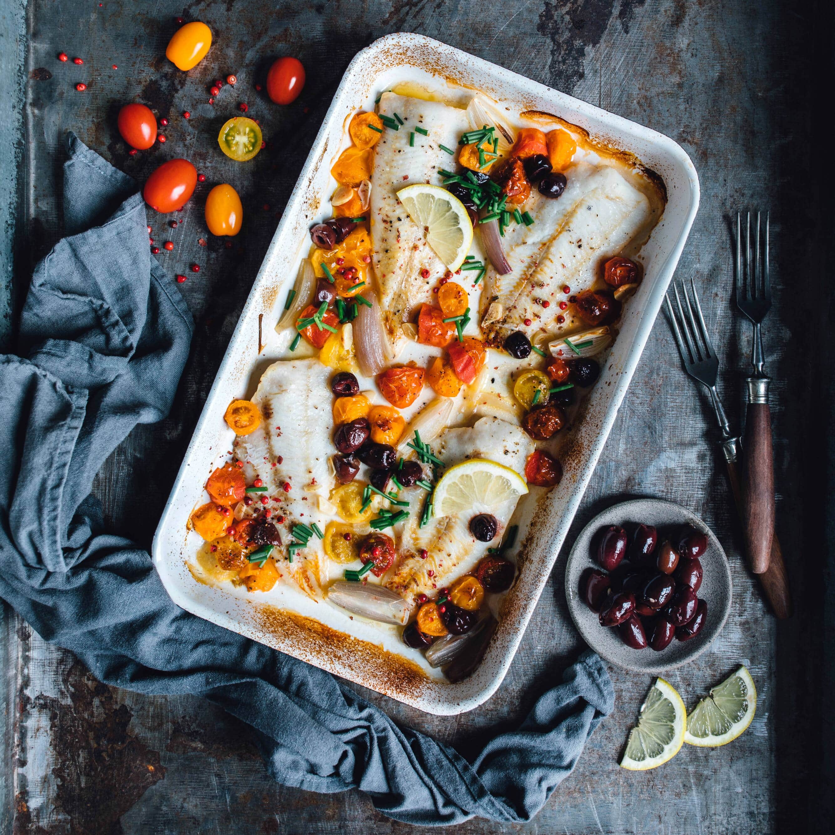 Ein schnelles und einfaches Rezept für die Zubereitung von Seehecht mit Tomaten und Oliven im Ofen. Dazu passt Baguette.