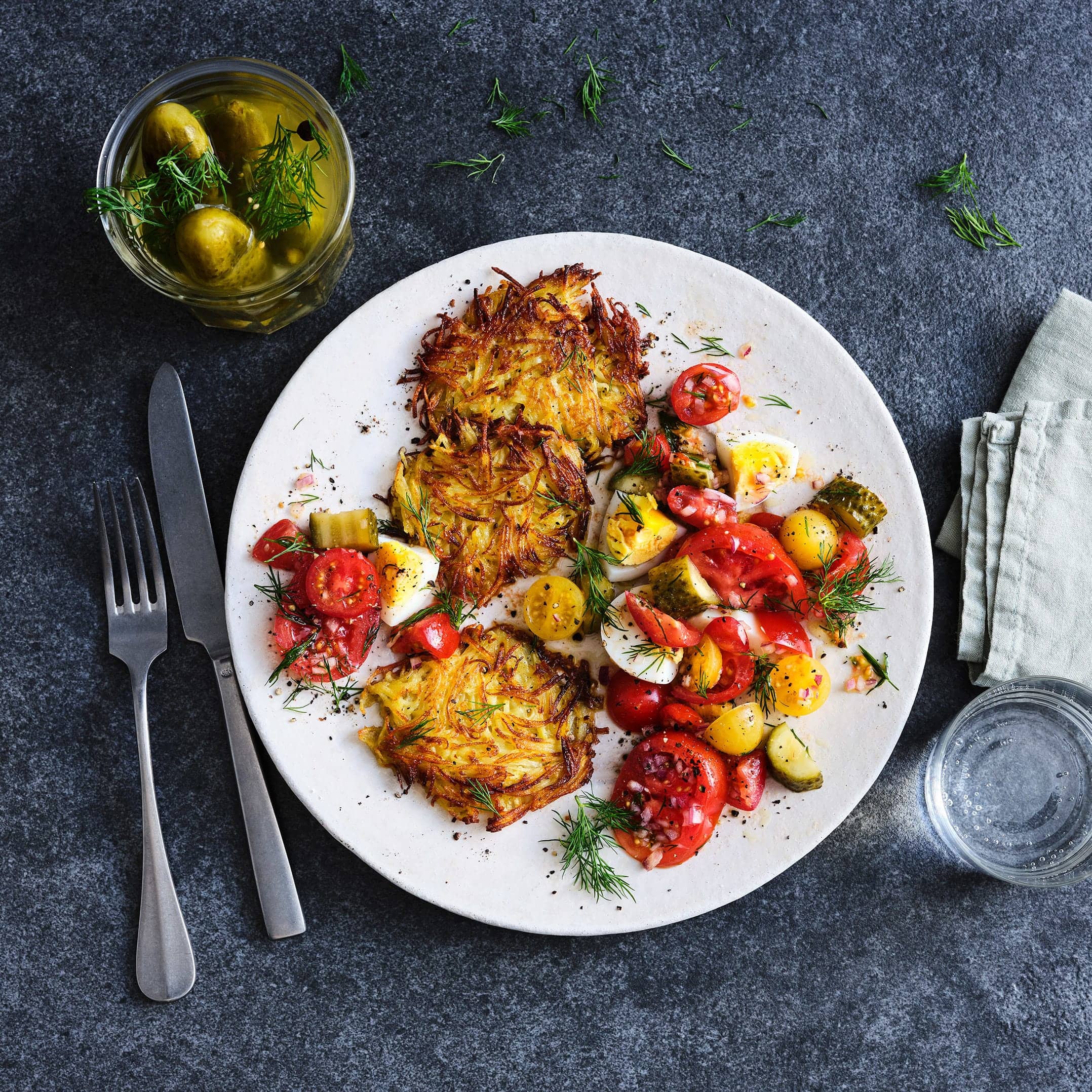 Knusprige Kartoffelrösti mit einem leckeren Salat aus Tomaten und Gewürzgurken: Alles was Sie brauchen sind 30 Minuten und 5 Zutaten sowie ein paar Kleinigkeiten aus dem Vorratsschrank.
