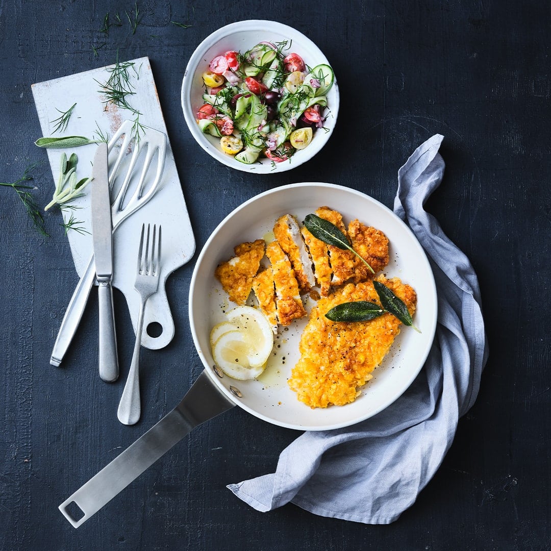 Die Cornflakes sorgen für eine richtig leckere und krosse Panade in unserem schnellen Rezept für Knusper-Schnitzel mit selbstgemachtem Gurkensalat.