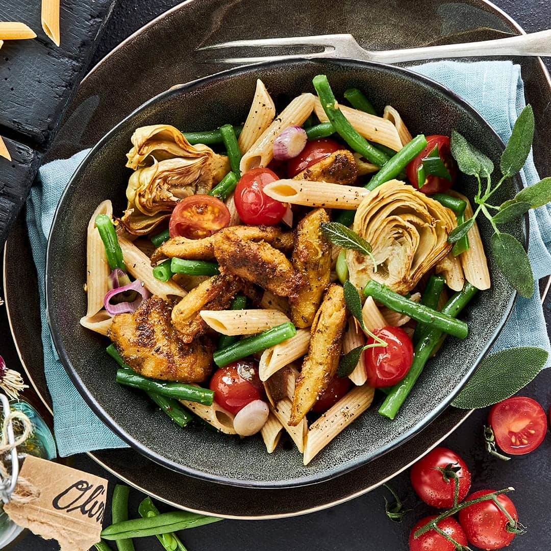 Genießen Sie unser vegetarisches Rezept für Penne Integrale mit gebratenen Artischocken-Herzen  – mit veganem Fleischersatz und vielen frischen Zutaten.