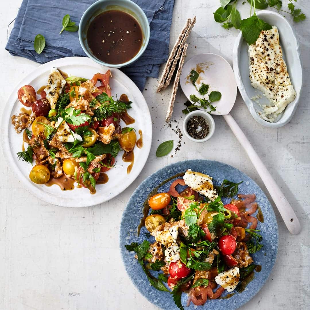 Knäckebrot mal anders – als Salat mit Tomaten, Lauchzwiebeln, Parmesan und Kräuterdressing. Und als griechisches Topping: gegrillter Feta.