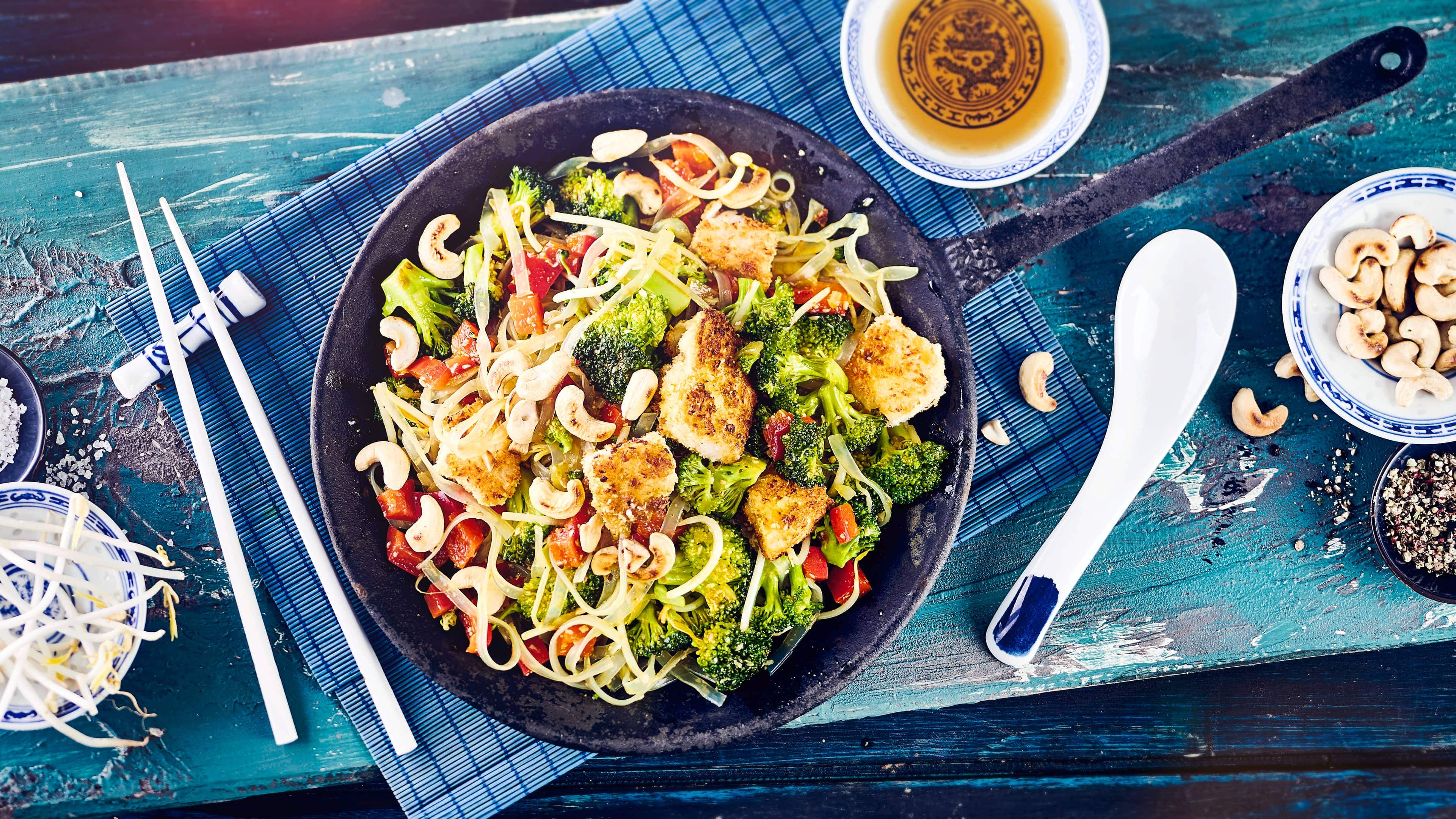 Asiatische Nudelpfanne Unser Rezept für eine asiatische Nudelpfanne ist gluten- und laktosefrei: Mit Broccoli, Kabeljau-Filet und Cashewkernen – probieren Sie es gleich mal aus!