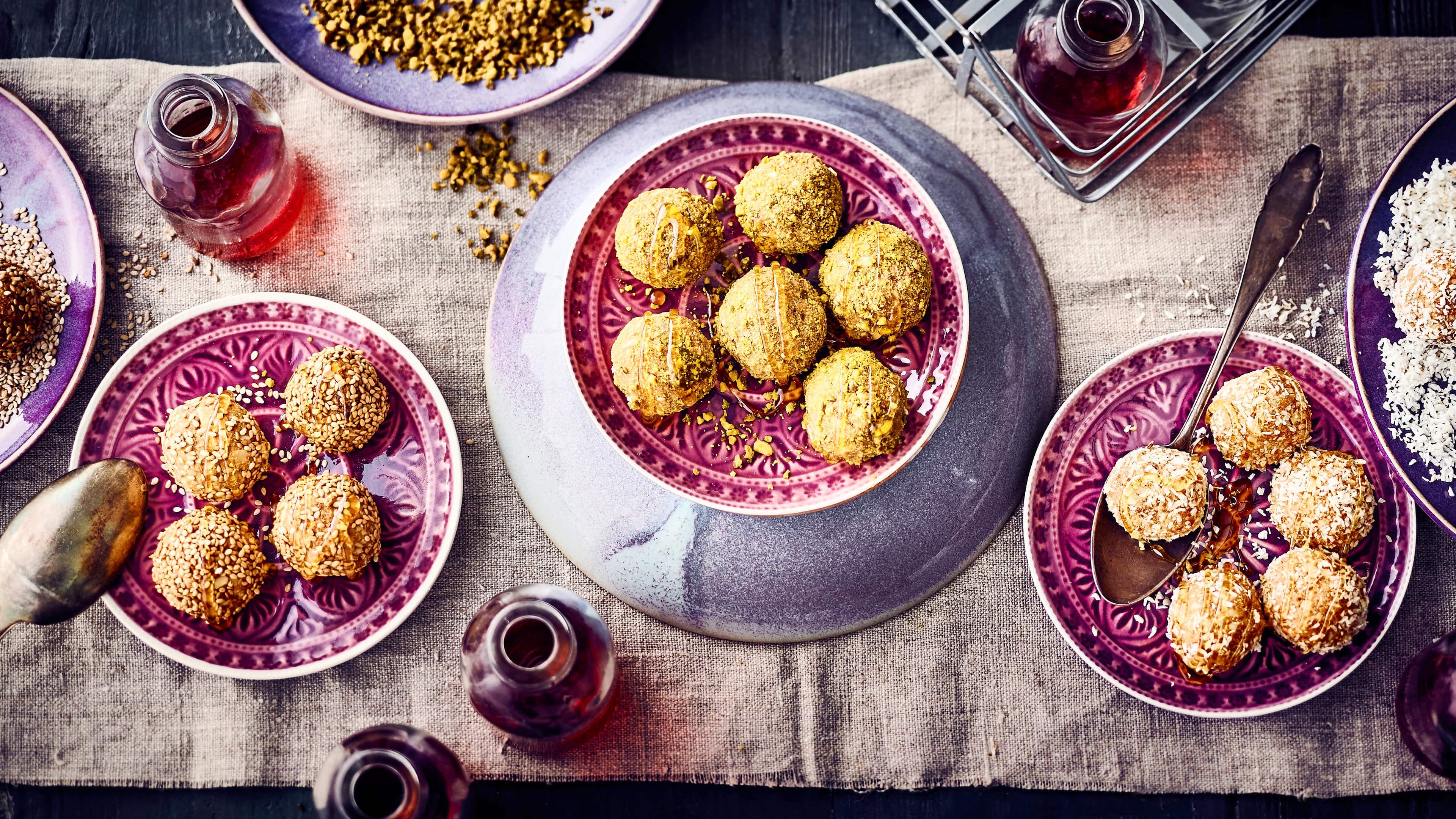 Laddu Laddu kommt aus Indien und sind kleine Bällchen, die aus Butter, Kichererbsenmehl, Mandeln und Datteln bestehen und anschließend zum Beispiel in gehackten Pistazien, Kokosraspeln oder Sesamsamen gewälzt werden.