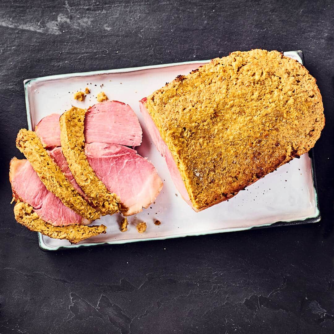 Auch als Julschinken oder schwedischer Weihnachtsschinken bekannt: Wir servieren den Schinkenbraten mit Senfkruste, Apfel-Rotkohl und gefächerten Hasselback-Kartoffeln.