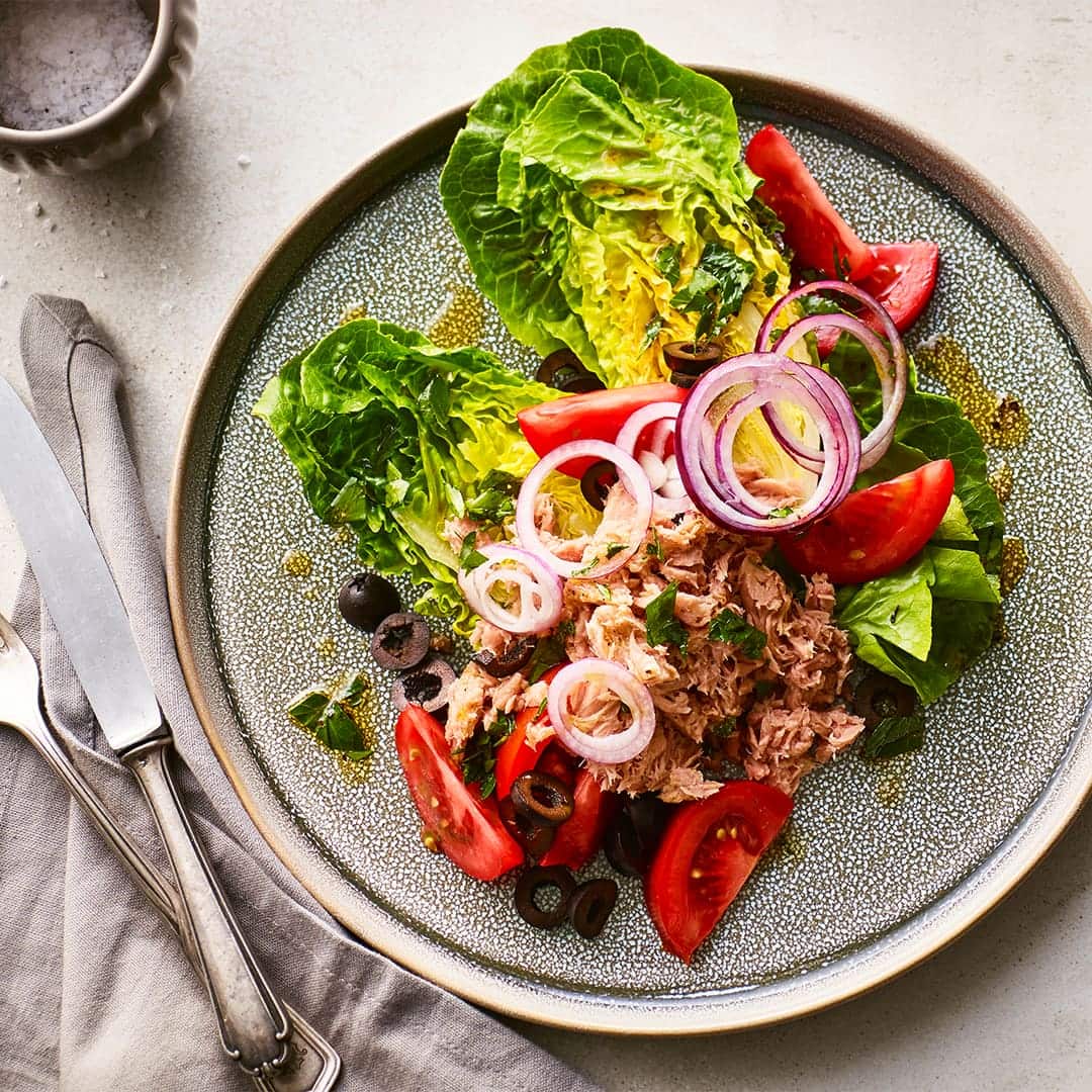 Knackig-frisches Gericht nach griechischer Art: Probieren Sie unsere Salatherzen mit Thunfisch, schwarzen Oliven und Tomaten an Avocado-Käse-Dip!
