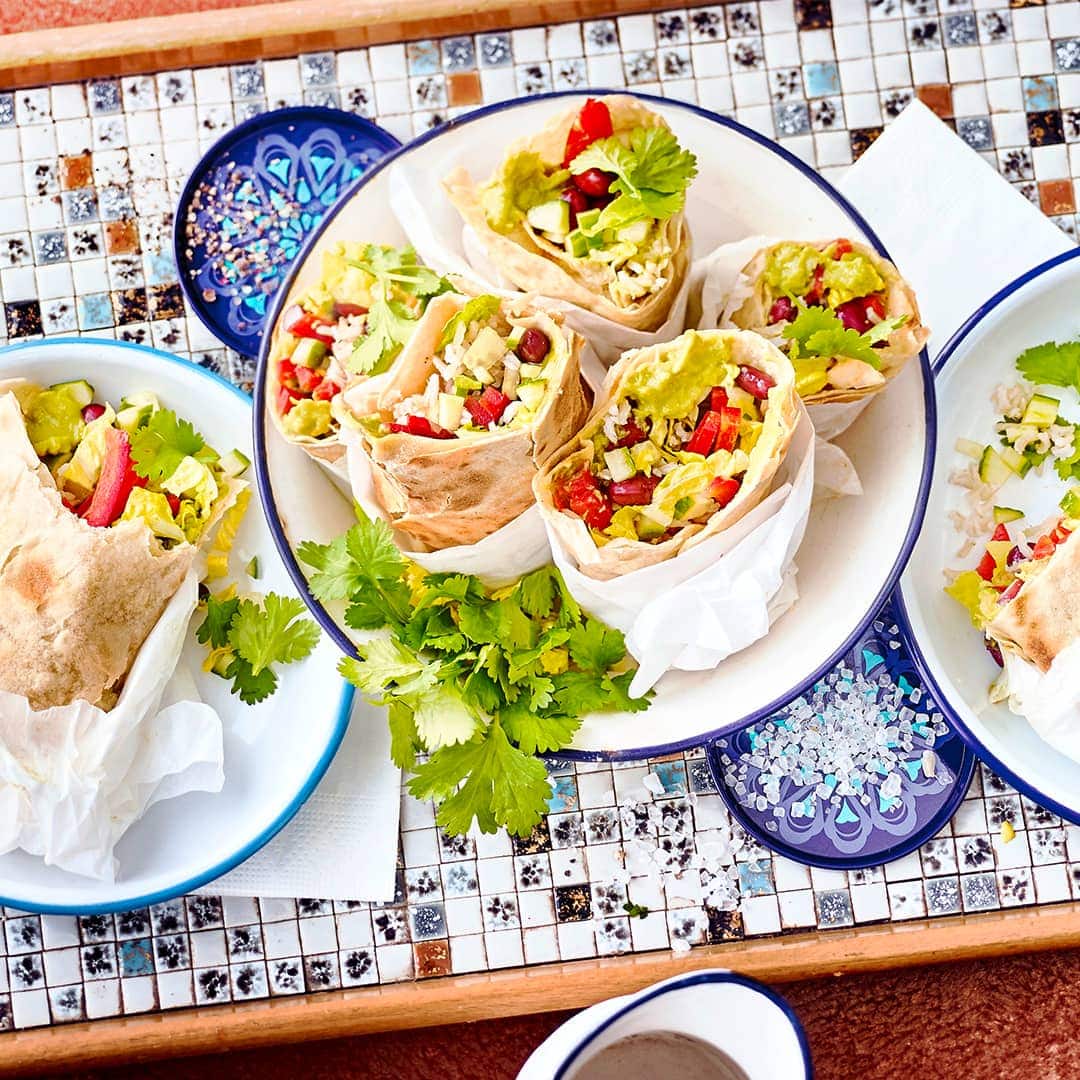 Selbst gemachte Tortillas, gefüllt mit frischem Gemüse, Guacamole, Bohnen und Reis. Ein besonderer Genuss. Probieren Sie unsere veganen mexikanischen Wraps.