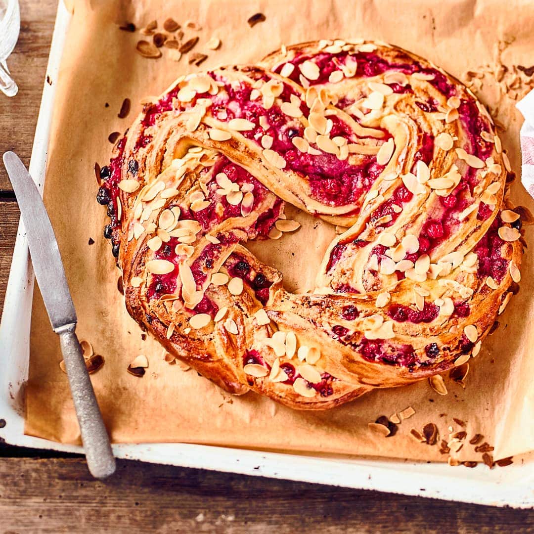 Ein Glanz auf der Kaffetafel: Köstlicher geflochtener Hefekranz mit einer fruchtigen Marzpian-Johannisbeerfüllung.