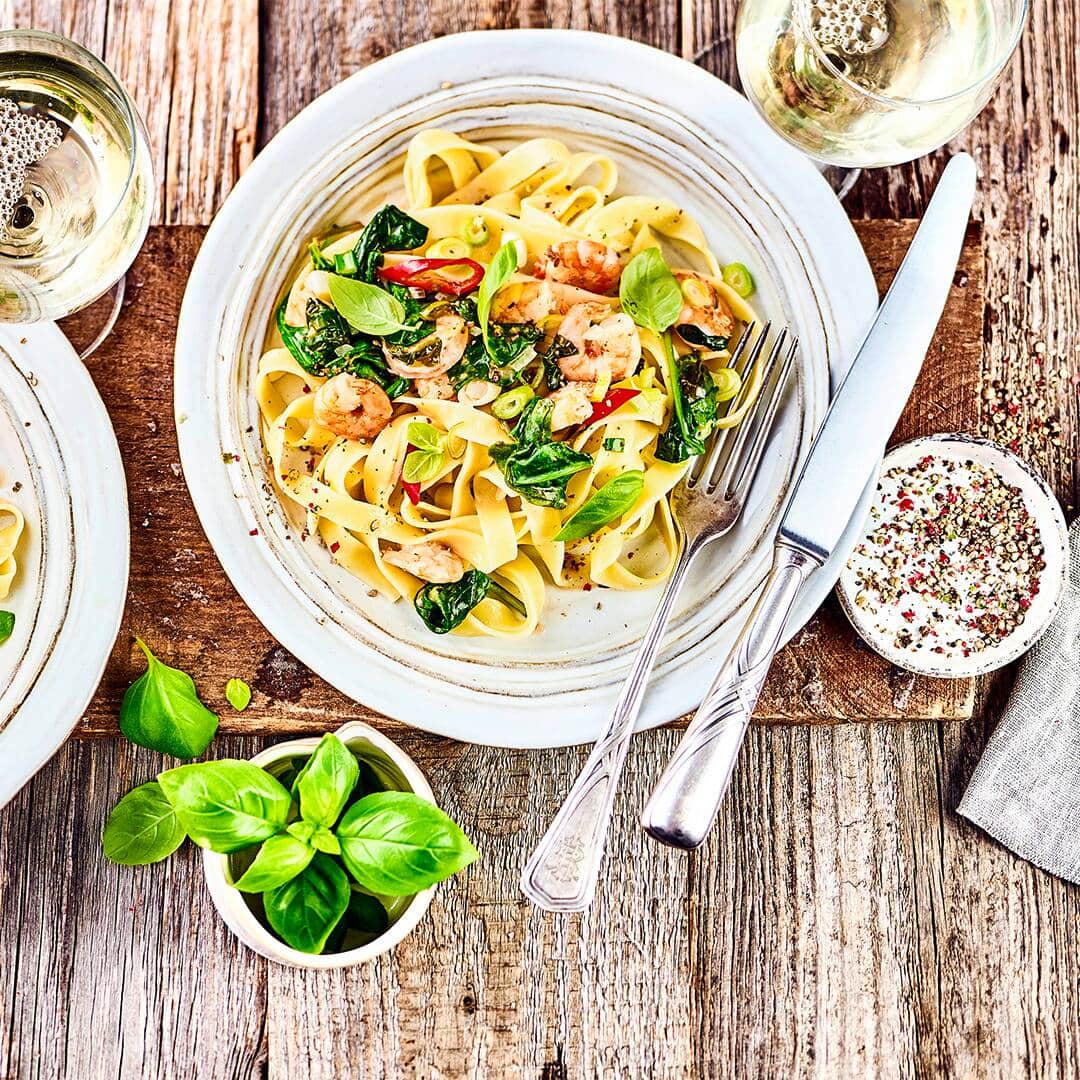 Schnelles Pastagericht mit Meeresfrüchten: Probieren Sie unsere Linguine mit Scampi, Spinat und Peperoni in Kokos-Soße – pikant und lecker!