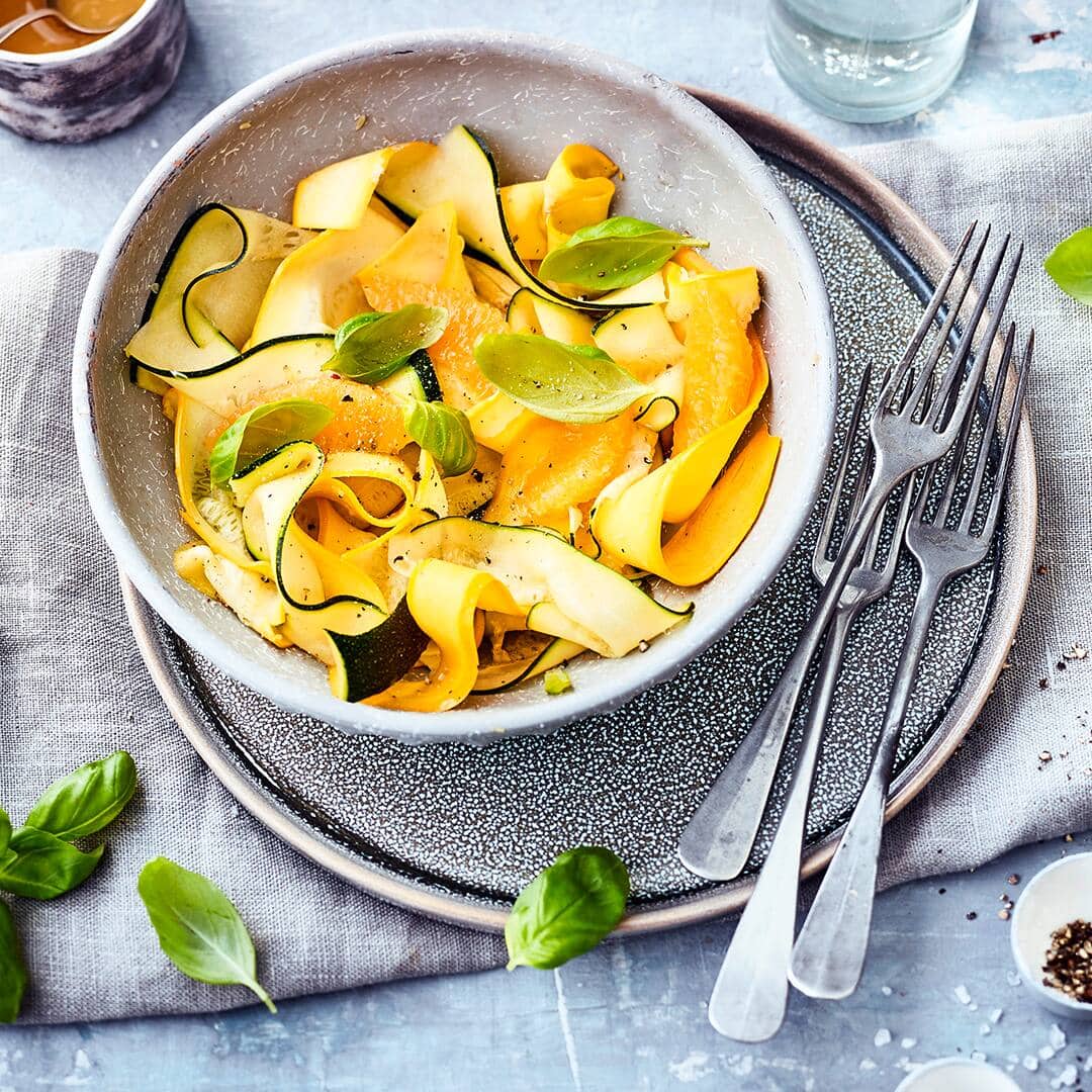 Mit unserem Zucchinisalat-Rezept stellen Sie eine einfache, aber raffinierte Vorspeise her. Orangendressing und Basilikum peppen das milde Gemüse auf.