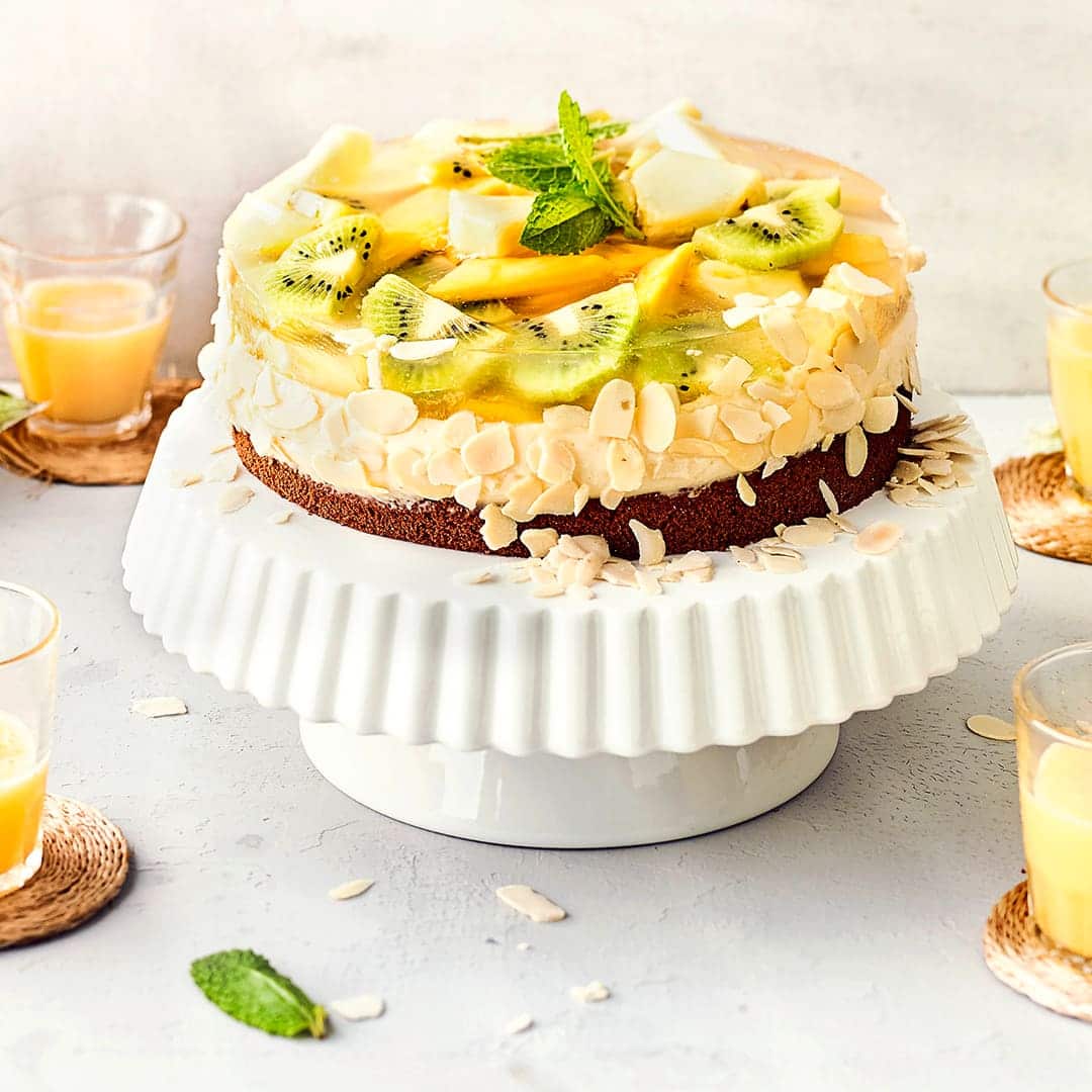 Genau das Richtige für den Kaffeetisch im Sommer: Unser exotischer Obstkuchen besteht aus einem Schokoladen-Boden mit Mandel-Creme und exotischen Früchten belegt.