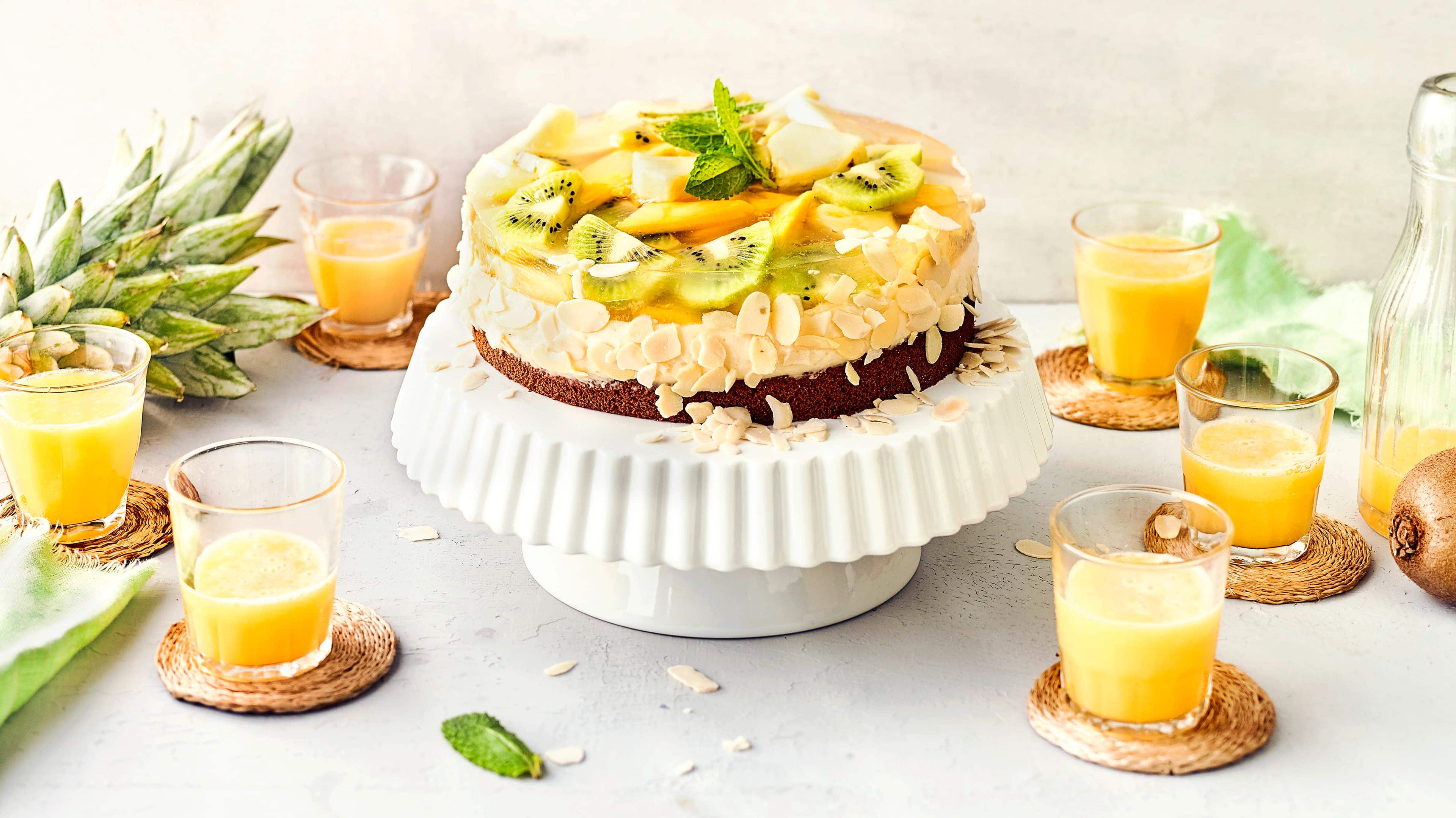 Exotischer Obstkuchen Genau das Richtige für den Kaffeetisch im Sommer: Unser exotischer Obstkuchen besteht aus einem Schokoladen-Boden mit Mandel-Creme und exotischen Früchten belegt.