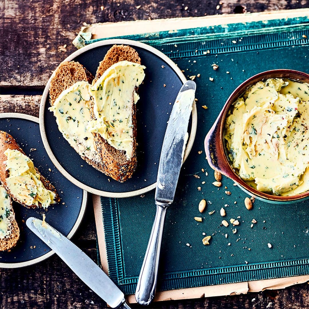 Mit unserem Rezept für selbstgemachte Kräuterbutter bereichern Sie jedes Party-Büfett: Probieren Sie unsere Variante mit Löwenzahn, Bärlauch, Salz und Pfeffer – fertig in 10 Minuten!