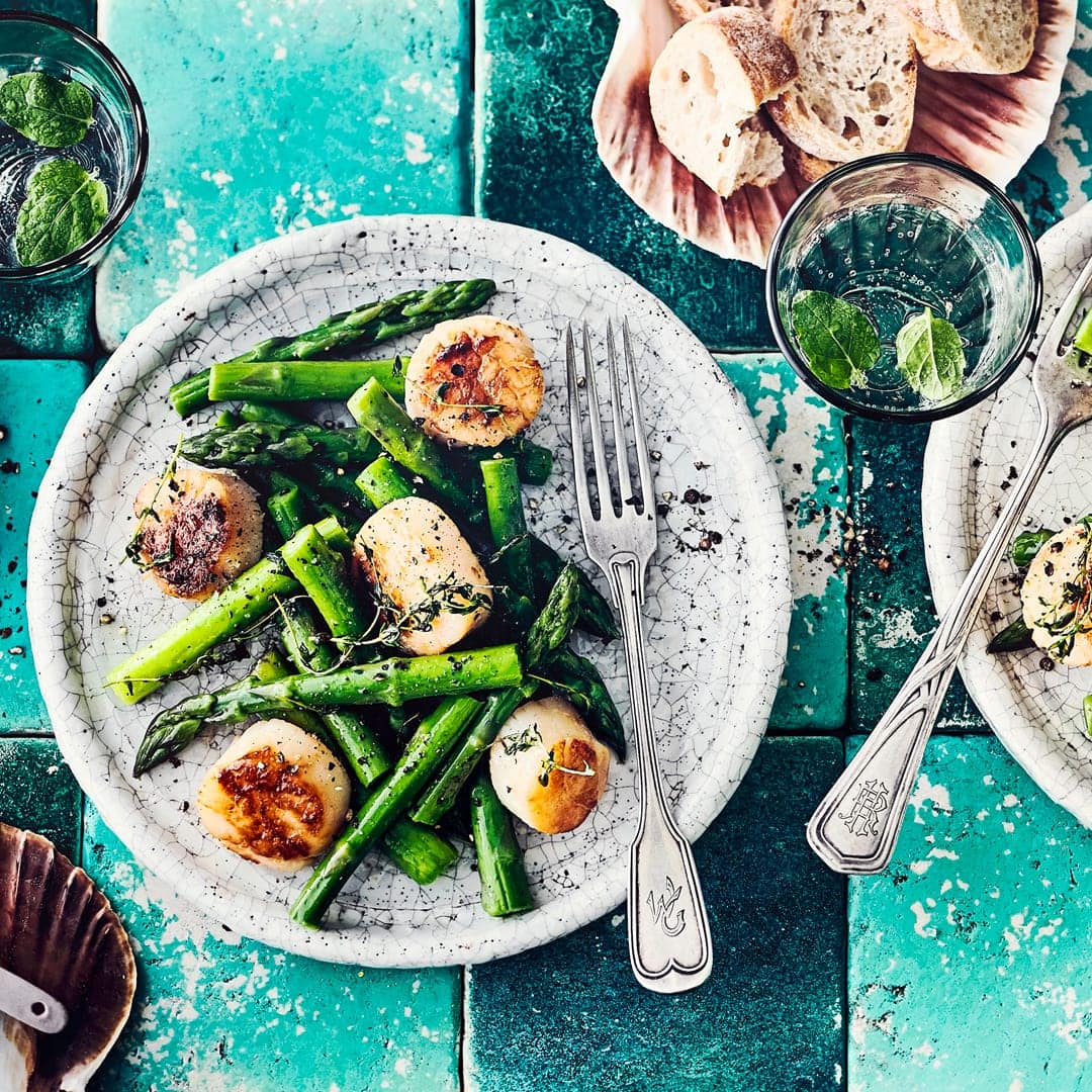 Dieses leckere Sommergericht mit Meeresfrüchten haben Sie in gut 20 Minuten zubereitet: Probieren Sie unser Rezept für Jakobsmuscheln mit grünem Spargel einmal aus – gebraten in Olivenöl mit Zitronensaft und Thymian!