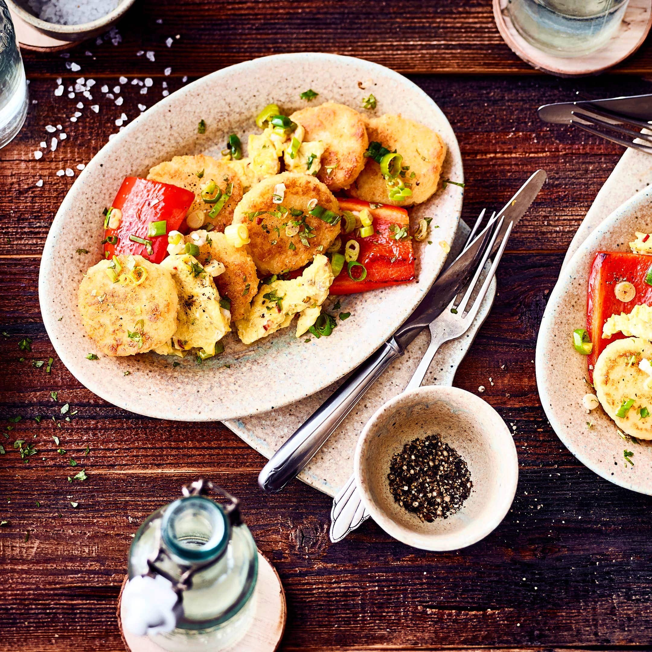 Kartoffelknödel einmal anders zubereitet: In unserem Rezept für geröstete Kartoffelknödel werden die zuvor gekochten Knödel mit Frühlingszwiebeln, Paprika und Eiern in der Pfanne geröstet.