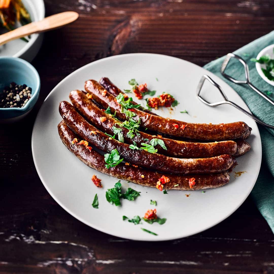 Deftiges für den Grill: Probieren Sie unsere Lammwürstchen mit Harissa, einer scharfen Gewürzpaste aus Chili, Kümmel, Curry und frischen Kräutern!