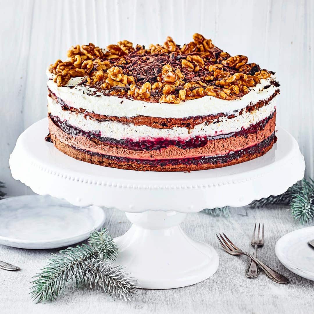 Dunkle Biskuitteig-Böden mit einer Cremefüllung aus Schokolade, Karamell-Walnüssen und Sahne. Eine festliche Torte für den Adventskaffee!