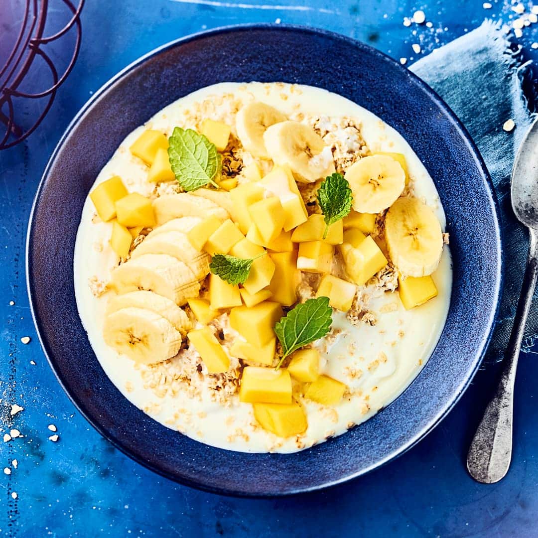 Frühstücken Sie sättigende Haferflocken mit Mango und Banane. Gesüßt wird der dazu gegessene Joghurt mit Honig – schnell und einfach zubereitet!