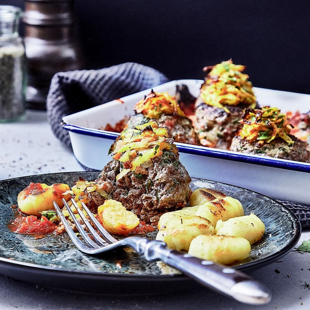 Deftiges Wintergericht: Probieren Sie unsere Frikadellen aus Hackfleisch mit einer knusprigen Haube aus Karotte und Sellerie, dazu Gnocchi und Tomatensoße!