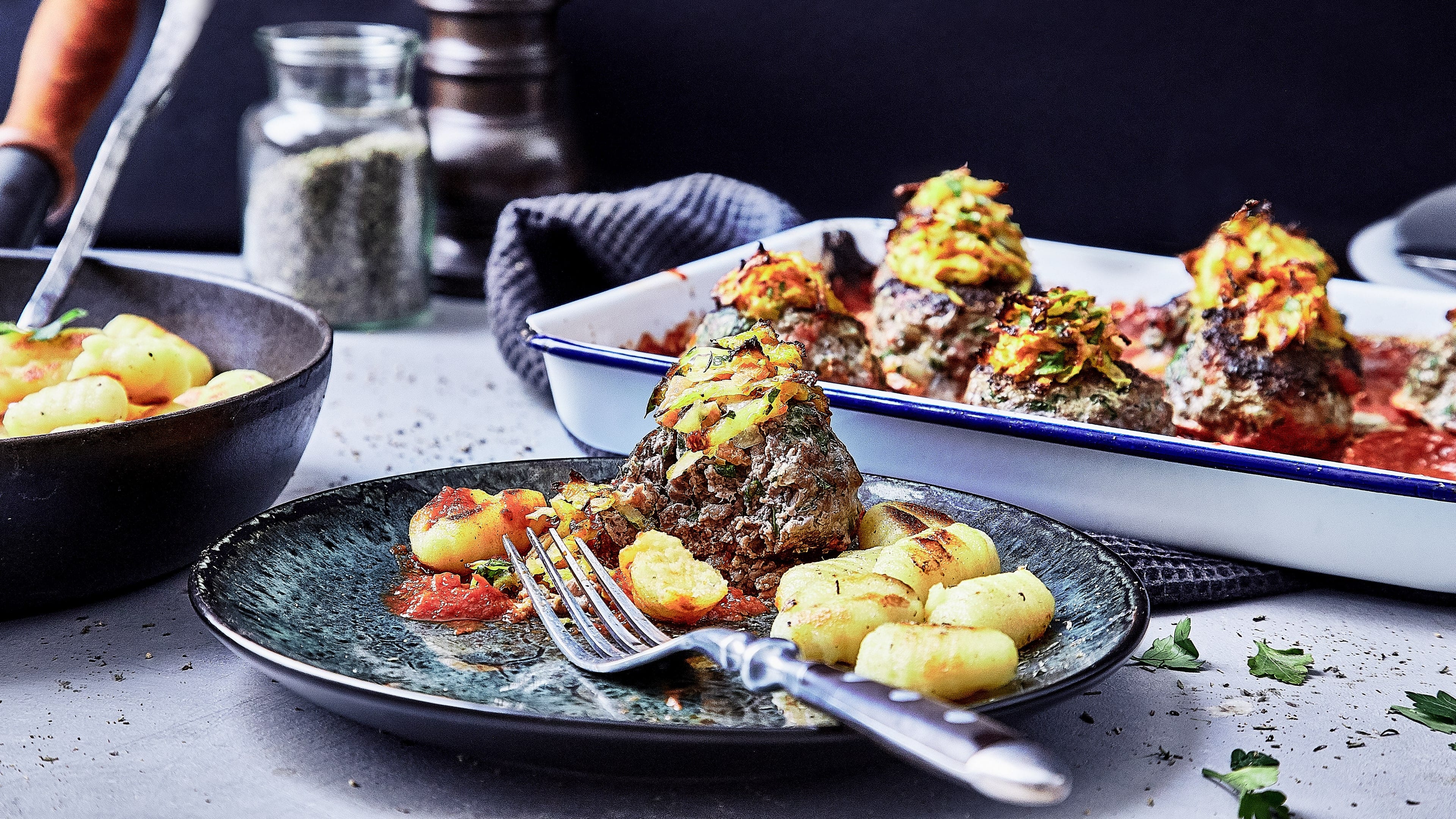 Frikadellen mit Gemüsehaube Deftiges Wintergericht: Probieren Sie unsere Frikadellen aus Hackfleisch mit einer knusprigen Haube aus Karotte und Sellerie, dazu Gnocchi und Tomatensoße!