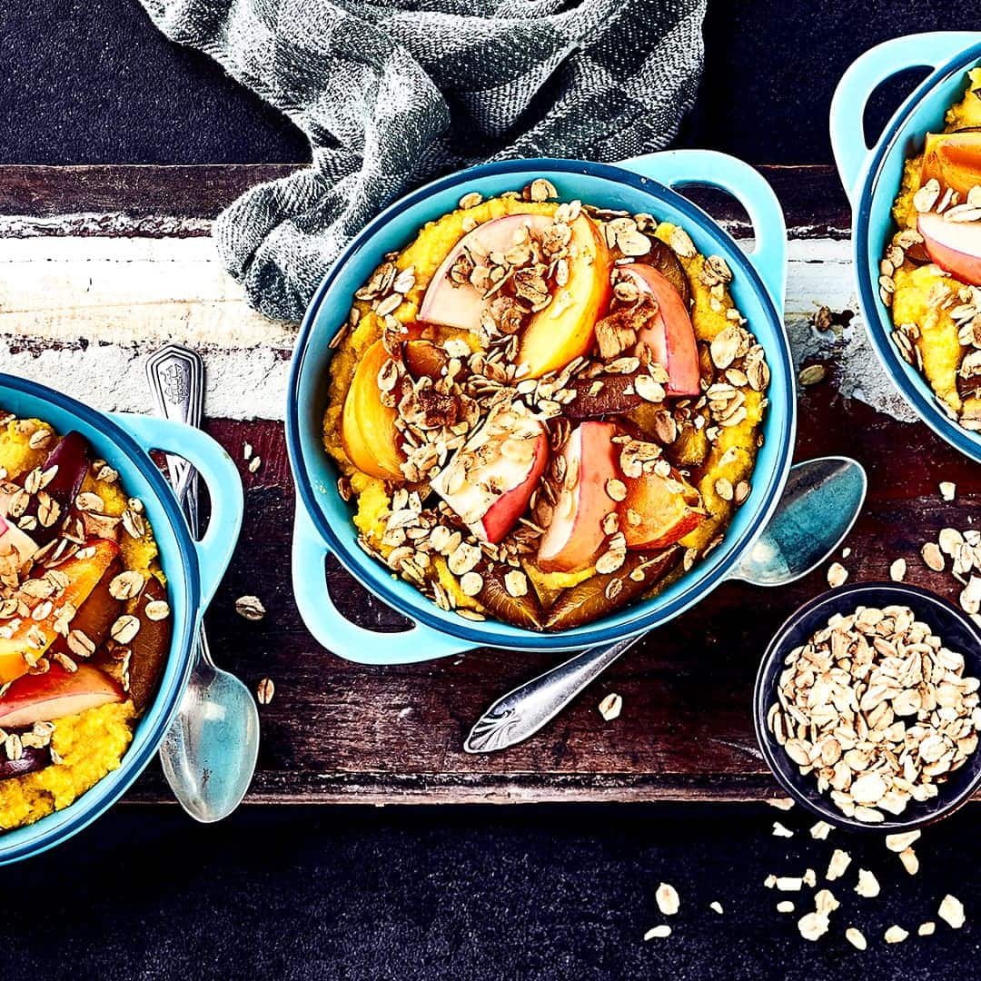 Leckeres Dessert zur Herbstzeit: Probieren Sie unser Crumble mit Pflaumen, Kakis und einem knusprigen Topping aus Apfel-Zimt-Müsli – warm aus dem Backofen!