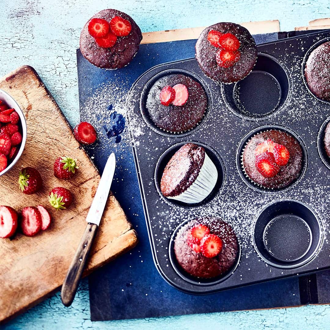 Einfach köstlich und der Hit auf jeder Geburtstags-Party, aber z.B. auch zu Muttertag: Selbstgemachte Schokoladen-Muffins mit Puderzucker und Erdbeeren.