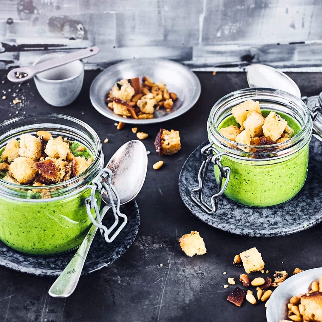 Begeistern Sie Ihre Gäste mit unserem Rezept für eine vegetarische Erbsen-Spinat-Suppe mit Pinienkern-Crouton-Topping – unbedingt gleich ausprobieren!