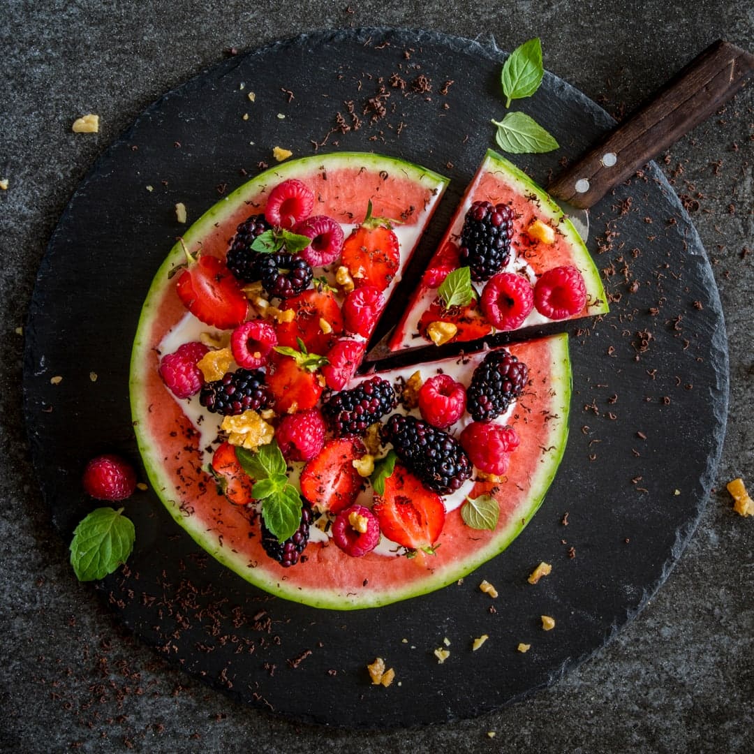 Das perfekte Frühstück für den Sommer oder als frischer Snack für Zwischendurch: Eine fruchtig belegte Melonenpizza mit Joghurt-Honig-Sauce und karamellisierten Walnüssen.