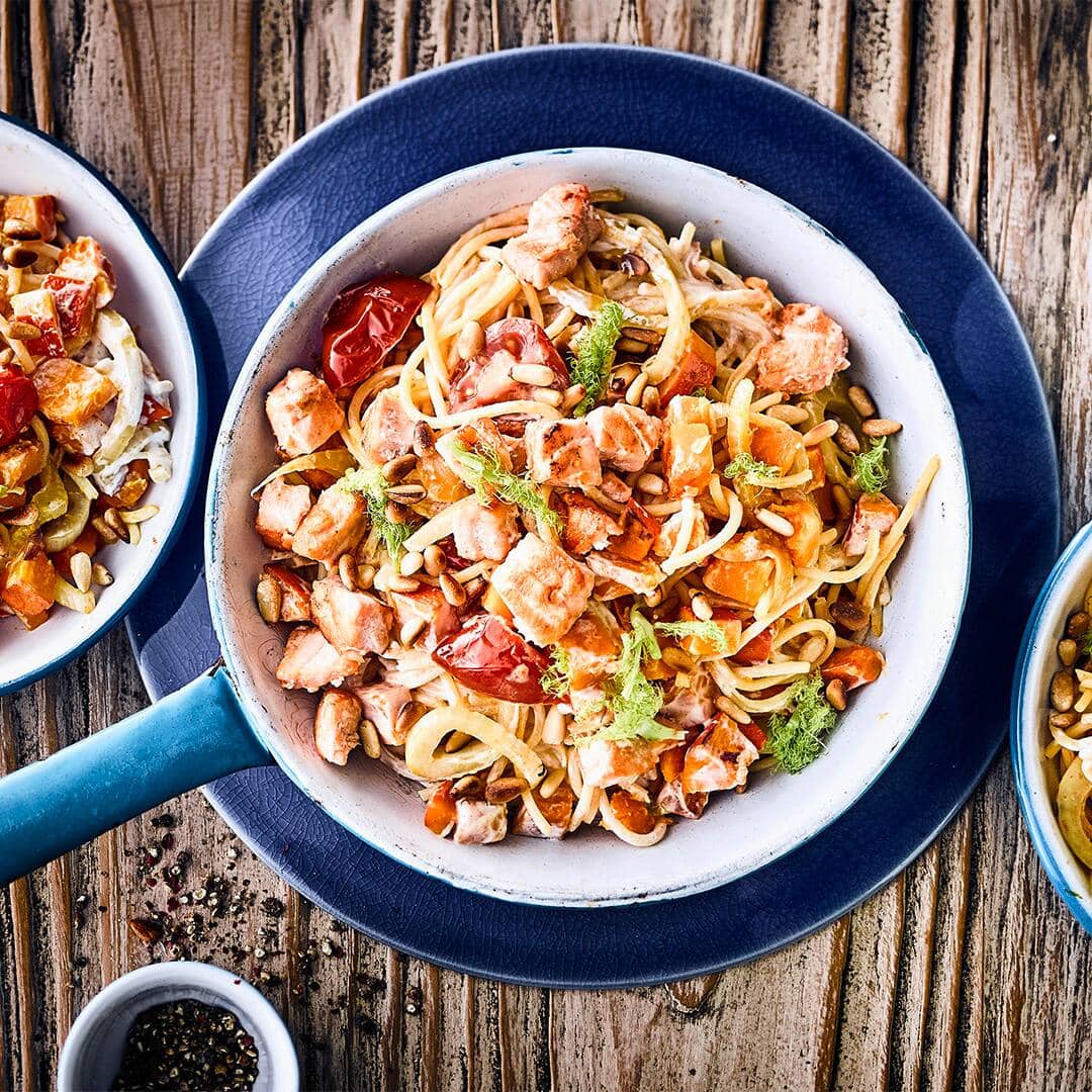 Zaubern Sie mit unserem Rezept ein mediterranes Spaghetti-Gericht mit Kürbis, Lachs und Fenchel – verfeinert mit Sauerrahm und Pinienkernen!