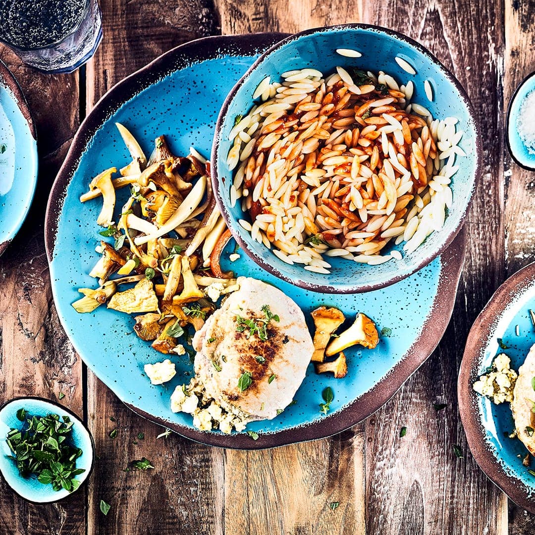 Unser Tipp für ein mediterranes Abendessen: Probieren Sie unser Rezept für gefüllte Steaks mit Käse und Pesto an Pfifferlinggemüse und Kritharaki aus.