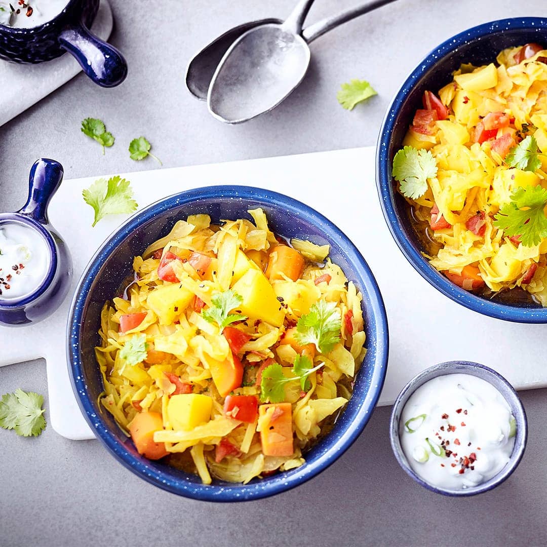 Curry mal anders: Unser Rezept für ein vegetarisches Curry mit Weißkohl, Kartoffeln, Karotten und Tomaten - dazu ein Koriander-Dip.
