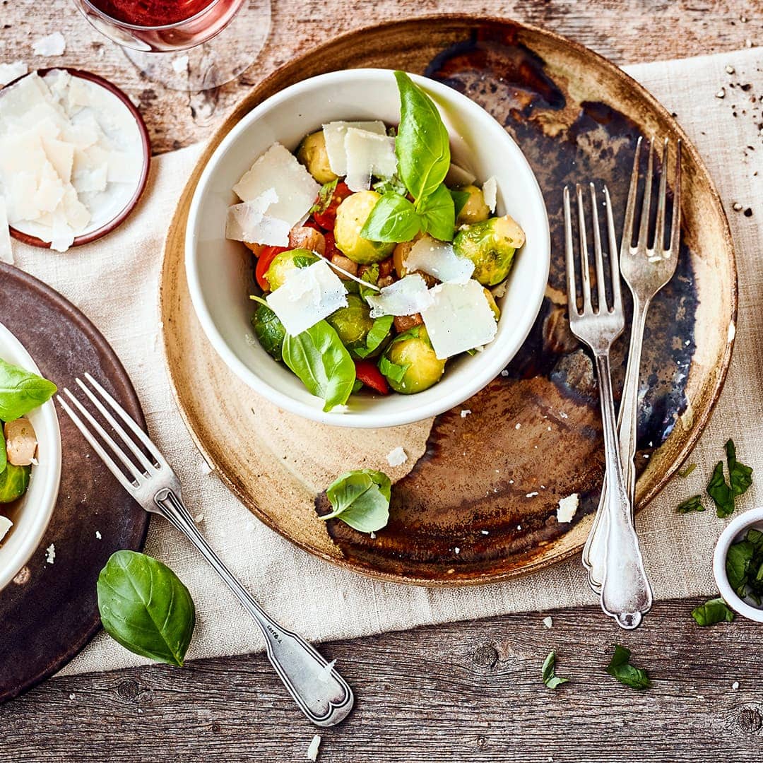 Tomaten, Zwiebel, Speck und Parmesan runden das Rosenkohl-Gemüse ab.
