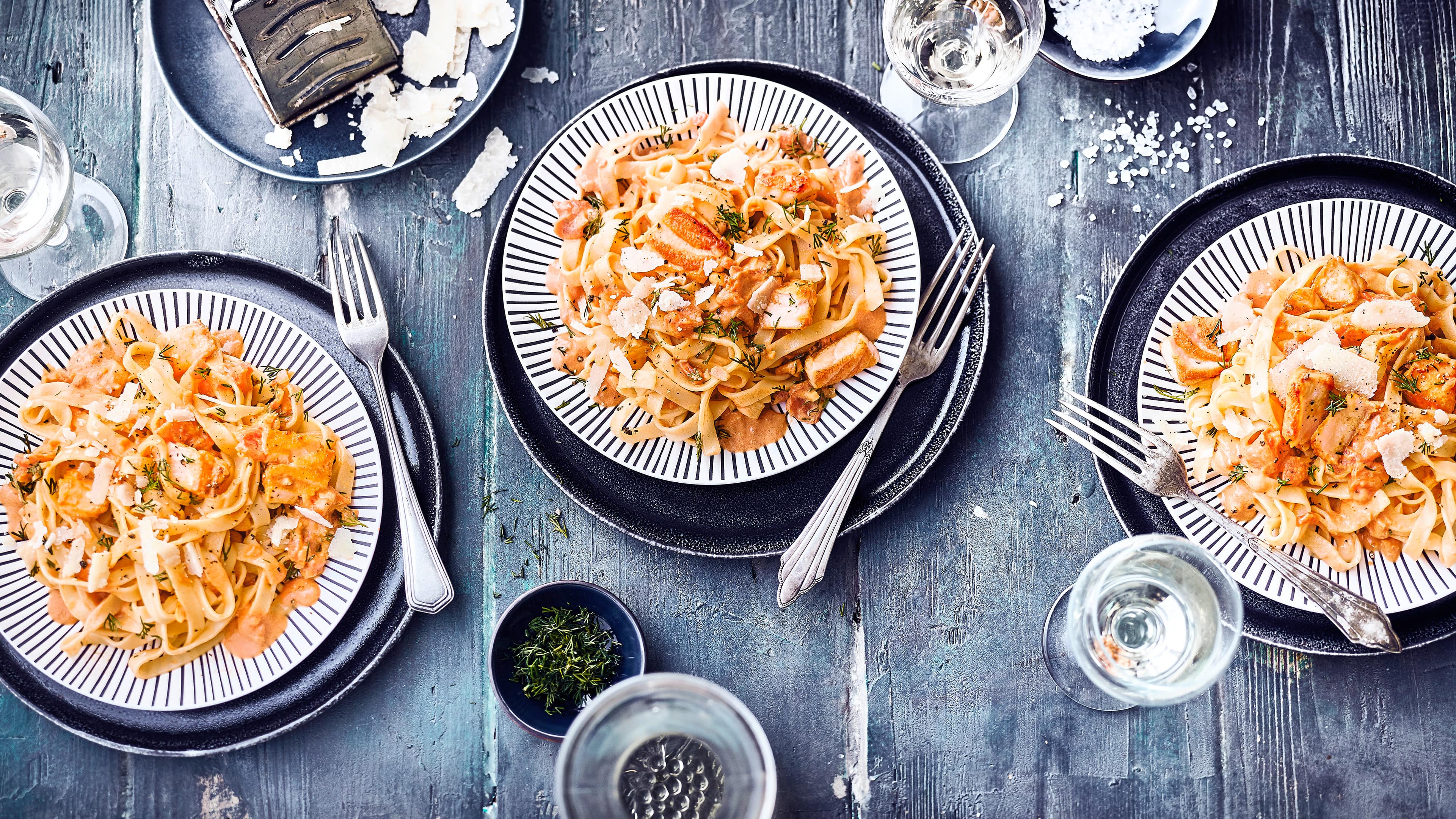 Tagliatelle al Salmone Köstlich wie beim Italiener: Tagliatelle al Salmone – Lachs in cremiger Weißwein-Sahne-Soße mit Tomaten verfeinert.