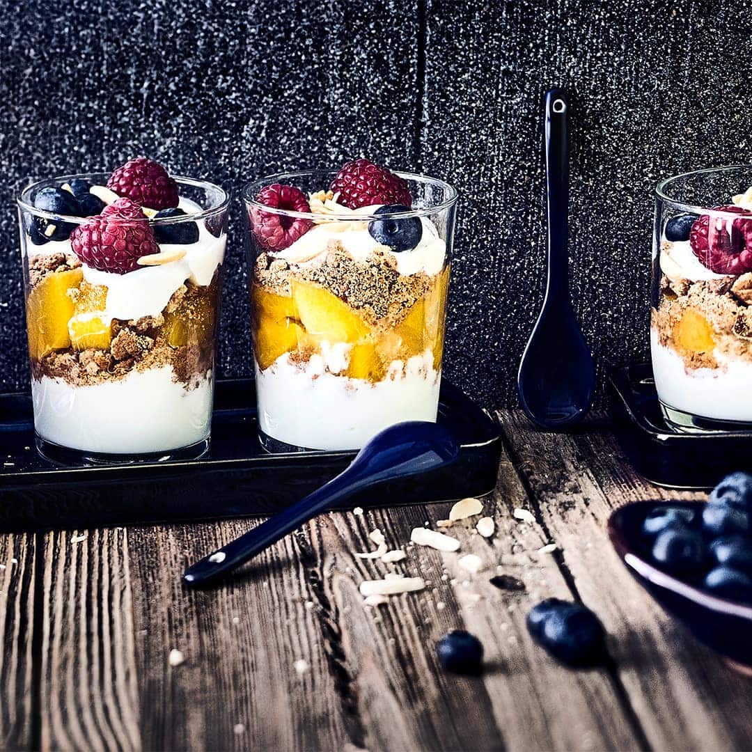 Leckere Nachspeise in nur 30 Minuten: Probieren Sie unser Schicht-Dessert mit frischen Beeren, Pfirischen, Joghurt und Vollkorn-Haferkeksen!