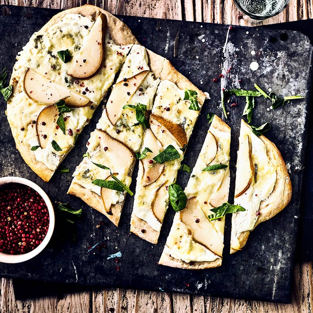Backen Sie einen herzhaften Hefeteig und belegen Sie ihn mit frischen Birnen, Zitrone, Frischkäse oder Gorgonzola für einen leckeren Flammkuchen.