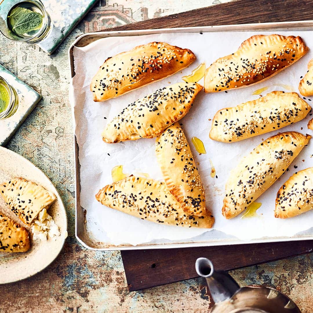 Türgische Pogaca sind köstliche kleine Teigtaschen mit würziger Kartoffel-Feta-Füllung und mit zweierlei Sesam bestreut.